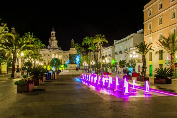 Cadiz 'de Aziz John Meydanı' ndaki bir çeşmenin gece görüşü. Arka planda belediye binası var.