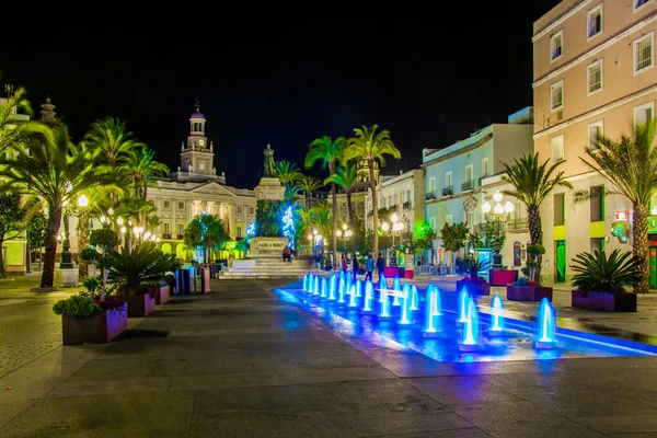 Cadiz 'de Aziz John Meydanı' ndaki bir çeşmenin gece görüşü. Arka planda belediye binası var.
