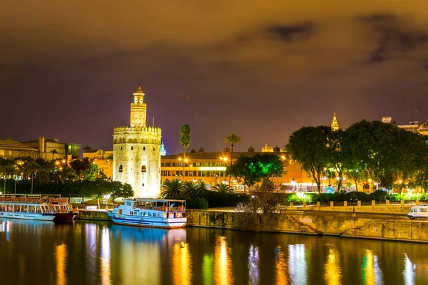 Guadalquivir nehri boyunca uzanan Altın Kule 'nin (Torre del Oro) gece görüşü, Sevilla (Endülüs), İspanya.