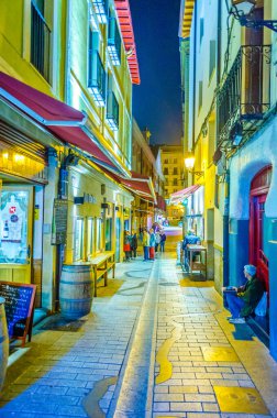 People are strolling a street in Logrono during nigh