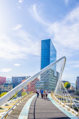 İnsanlar Bilbao, Spai 'deki Zubizuri köprüsünden geçiyorlar.