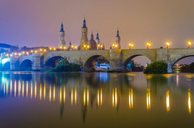 Zaragoza, Spai 'deki Basilica de nuestra senora de pilar ve puente de piedra' nın gece görüşü.