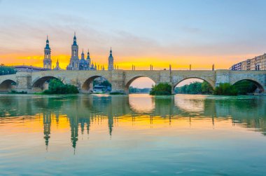 Zaragoza, Spai 'deki Basilica de nuestra senora de pilar ve puente de piedra' nın günbatımı manzarası.