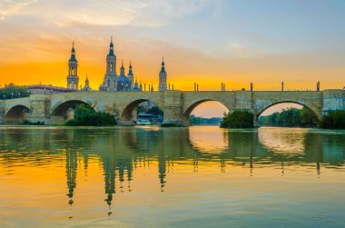 Zaragoza, Spai 'deki Basilica de nuestra senora de pilar ve puente de piedra' nın günbatımı manzarası.