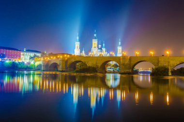 Zaragoza, Spai 'deki Basilica de nuestra senora de pilar ve puente de piedra' nın gece görüşü.