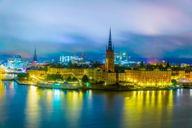 Stockholm, İsveçli Riddarholmskyrkan (Riddarholmen Kilisesi) tarafından yönetilen Gamla Stan 'in gece görüşü