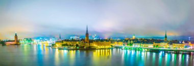 Stockholm 'ün gece panoramasında Stadshuset belediye binası, Riddarholmskyrkan kilisesi ve eski Gamla Stan kasabası da var.