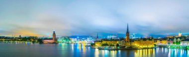 Stockholm 'ün gece panoramasında Stadshuset belediye binası, Riddarholmskyrkan kilisesi ve eski Gamla Stan kasabası da var.