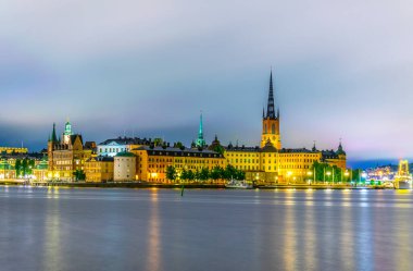 Stockholm, İsveçli Riddarholmskyrkan (Riddarholmen Kilisesi) tarafından yönetilen Gamla Stan 'in gece görüşü