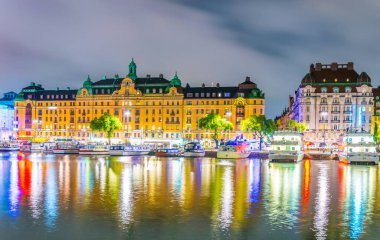 Stockholm rıhtımının gece manzarası ve yanında İsveççe uzanan güzel eski evler.