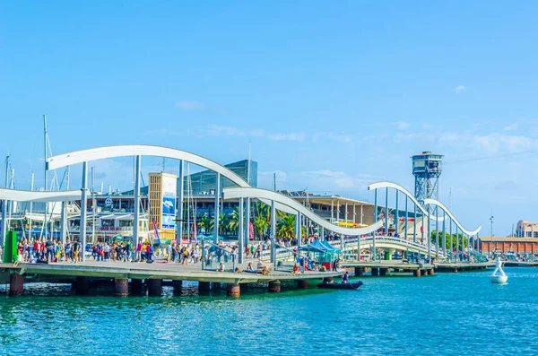 İnsanlar Barselona, İspanya 'daki Rambla de Mar gezinti güvertesinde geziniyorlar.
