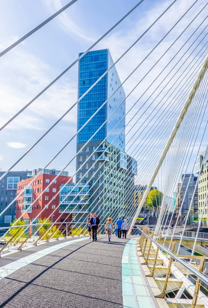 İnsanlar Bilbao, Spai 'deki Zubizuri köprüsünden geçiyorlar.