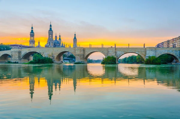 Zaragoza, Spai 'deki Basilica de nuestra senora de pilar ve puente de piedra' nın günbatımı manzarası.