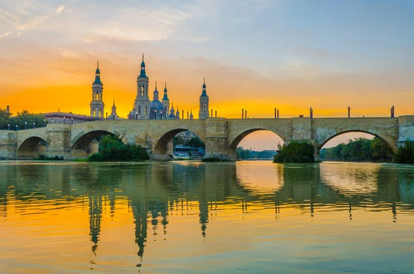 Zaragoza, Spai 'deki Basilica de nuestra senora de pilar ve puente de piedra' nın günbatımı manzarası.