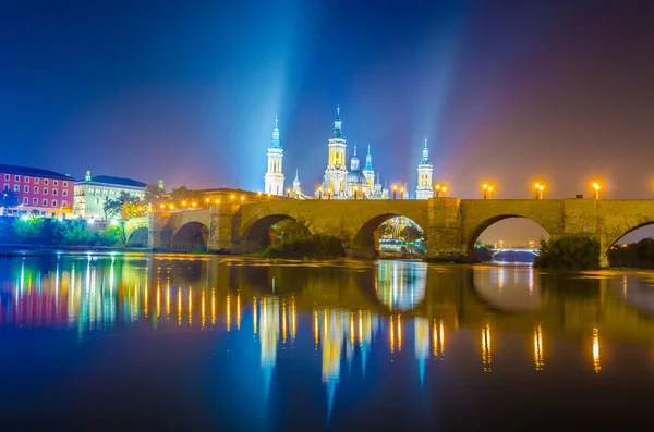 Zaragoza, Spai 'deki Basilica de nuestra senora de pilar ve puente de piedra' nın gece görüşü.