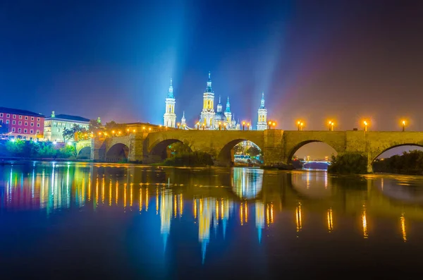 Zaragoza, Spai 'deki Basilica de nuestra senora de pilar ve puente de piedra' nın gece görüşü.
