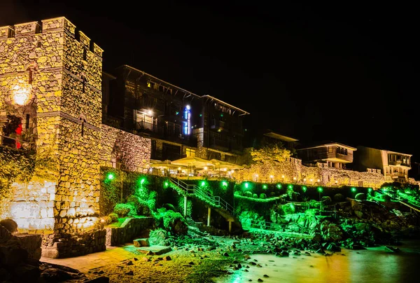 Şehri Karadeniz 'den ayıran antik duvarların egemen olduğu aydınlık eski Bulgar şehri Sozopol' un gece manzarası..