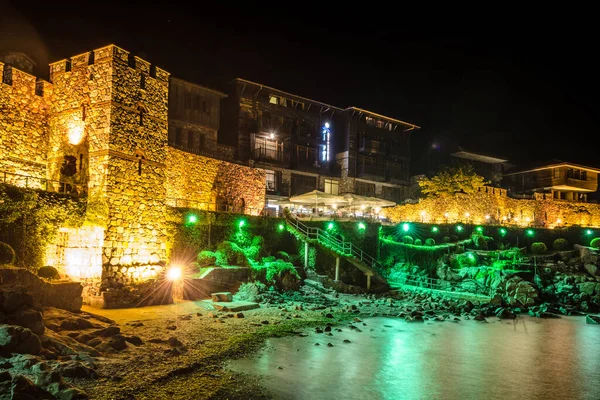 Şehri Karadeniz 'den ayıran antik duvarların egemen olduğu aydınlık eski Bulgar şehri Sozopol' un gece manzarası..