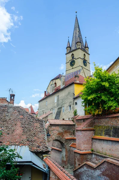 Romanya Sibiu 'sunun yukarısındaki tipik bir evin çatısı. Lüteryen Aziz Meryem Katedrali' nin kulesini görebilirsiniz.