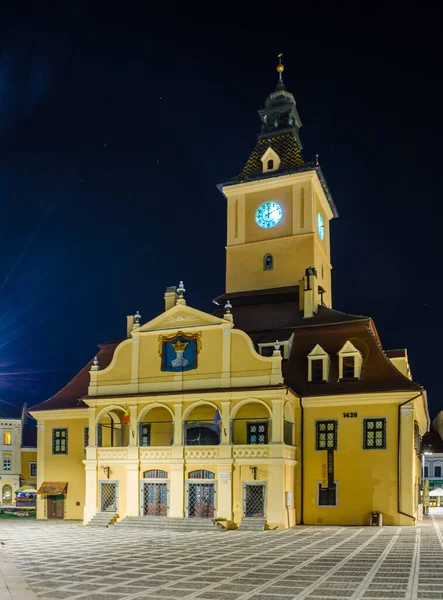 Romanya 'nın Brasov kentindeki aydınlık belediye binasının gece manzarası.