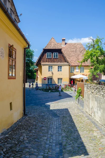 Romanya 'da ortaçağ tahkimatının yanında dolambaçlı bir caddede yer alan renkli evler görülüyor.