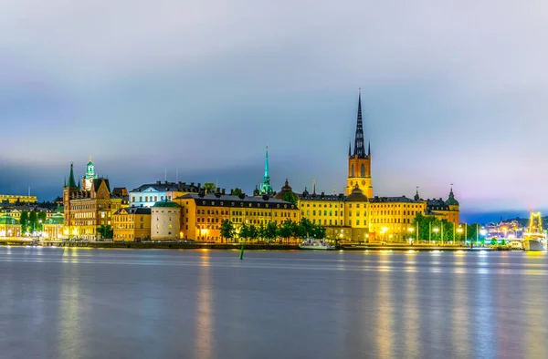 Stockholm, İsveçli Riddarholmskyrkan (Riddarholmen Kilisesi) tarafından yönetilen Gamla Stan 'in gece görüşü