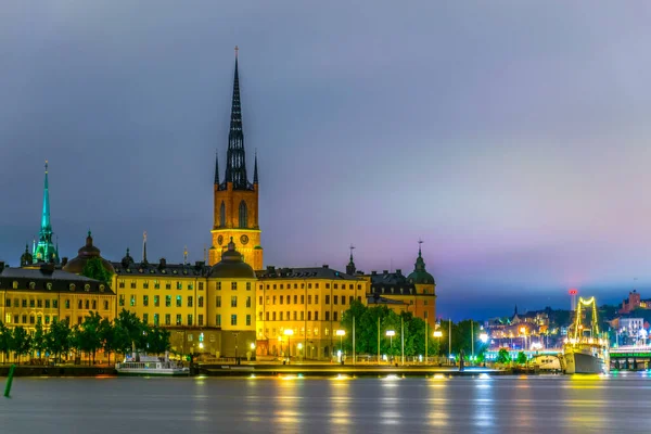 Stockholm, İsveçli Riddarholmskyrkan (Riddarholmen Kilisesi) tarafından yönetilen Gamla Stan 'in gece görüşü