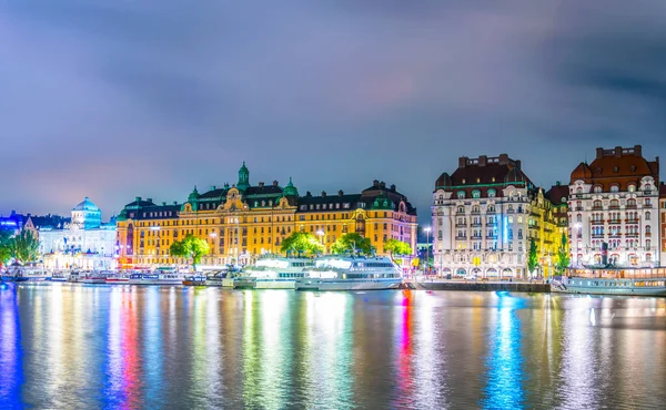 Stockholm rıhtımının gece manzarası ve yanında İsveççe uzanan güzel eski evler.