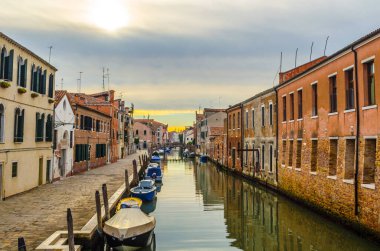 view of a minor channel with few boats swinging on ripples in Venice, italy