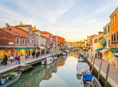 Sunset view of a channel on murano island in italy which is surrounded with tourist shops selling famous murano glas
