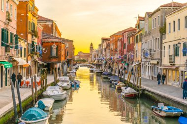 Sunset view of a channel on murano island in italy which is surrounded with tourist shops selling famous murano glas