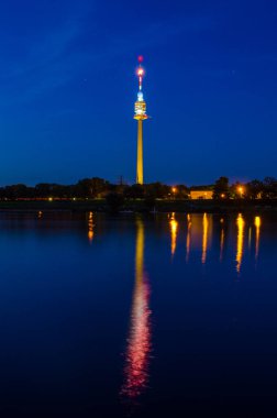 Viyana 'daki Donauturm Tuna Nehri' ni gece boyunca yansıtıyor