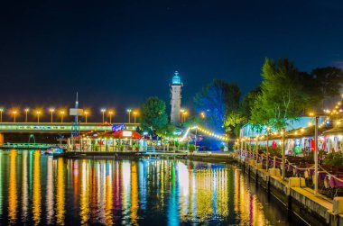 Viyana, Avusturya 'da Viyana ve Donauturm yakınlarındaki Donau nehrinin kıyısındaki restoranların gece görüşü.