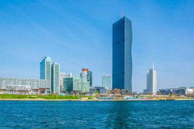 VİC, BM karargahı ve Avusturya 'nın Viyana kentinde bar ve restoranlarla dolu nehir kenarındaki bir gezinti alanı da dahil olmak üzere UNO şehir kompleksinin manzarası.