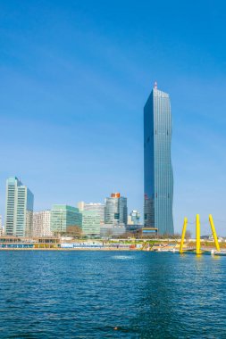 VİC, BM karargahı ve Avusturya 'nın Viyana kentinde bar ve restoranlarla dolu nehir kenarındaki bir gezinti alanı da dahil olmak üzere UNO şehir kompleksinin manzarası.