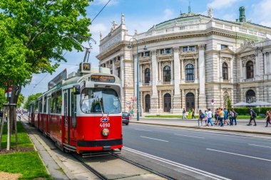 Famous Wiener Ringstrasse with historic Burgtheater (Imperial Court Theatre) and traditional red electric tram