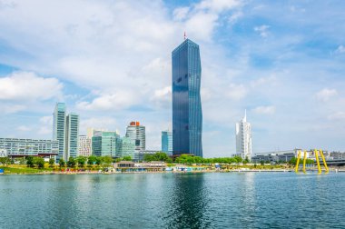VİC, Donauturm, BM karargahı ve Viyana, Avusturya 'daki barlar ve restoranlarla dolu nehir kenarındaki bir gezinti alanı da dahil olmak üzere UNO şehir kompleksinin manzarası.