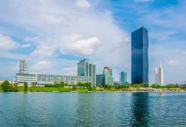 VİC, Donauturm, BM karargahı ve Viyana, Avusturya 'daki barlar ve restoranlarla dolu nehir kenarındaki bir gezinti alanı da dahil olmak üzere UNO şehir kompleksinin manzarası.
