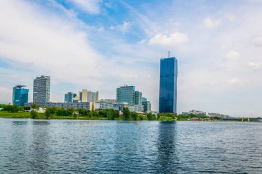 VİC, Donauturm, BM karargahı ve Viyana, Avusturya 'daki barlar ve restoranlarla dolu nehir kenarındaki bir gezinti alanı da dahil olmak üzere UNO şehir kompleksinin manzarası.