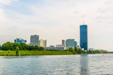 VİC, Donauturm, BM karargahı ve Viyana, Avusturya 'daki barlar ve restoranlarla dolu nehir kenarındaki bir gezinti alanı da dahil olmak üzere UNO şehir kompleksinin manzarası.