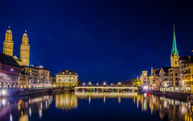 Grossmunster Katedrali 'nin gece manzarası, Munster Köprüsü ve İsviçre' nin Zuric şehrindeki sahtekar kilisesi.