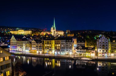Limmat Nehri 'nin doğu yakasının panoramik manzarası, Zürih' teki Predigerkirche ve Zürih Üniversitesi, İsviçre