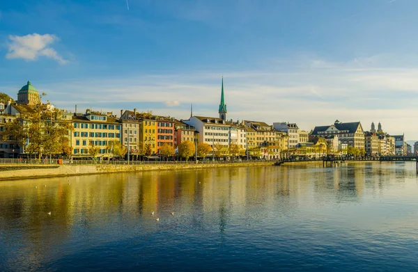 Nehir limmatı, güneşli bir sonbahar gününde tarihi Zürih şehir merkezinde, Zürih Kantonu, İsviçre 'de bulutlarla doluyor.