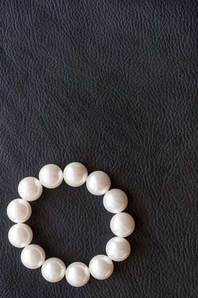 Perles blanches sur la soie noire comme fond — Photo