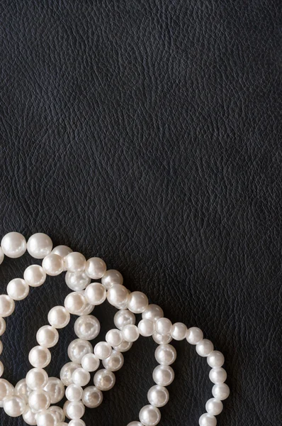 White pearls on the black silk as background — Stock Photo, Image