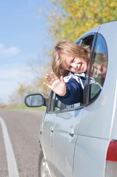 Girl waving from a car — Stock Photo, Image