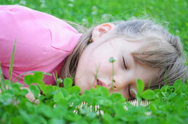 Giovane ragazza che dorme sull'erba verde — Foto Stock