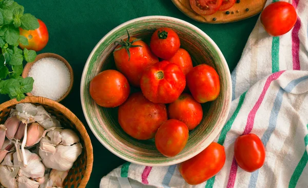 raw tomatoes and tomato on a green fabric