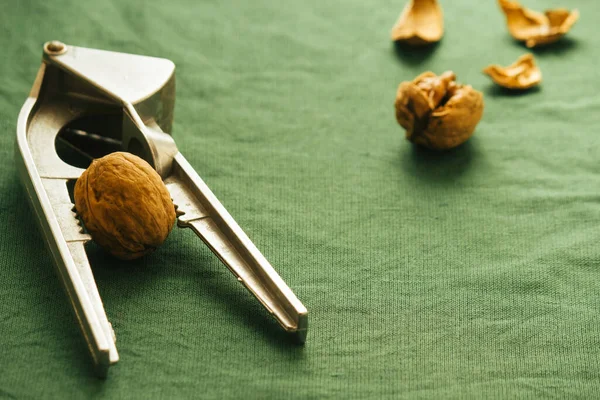 Nutcracker and walnuts on a green background 