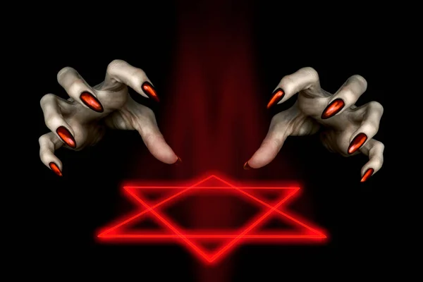 Svart magisk ritual. Skrämmande häxor händer med röda långa naglar och en brinnande hexagram symbol i mörkret, låg tonart, valt fokus. — Stockfoto